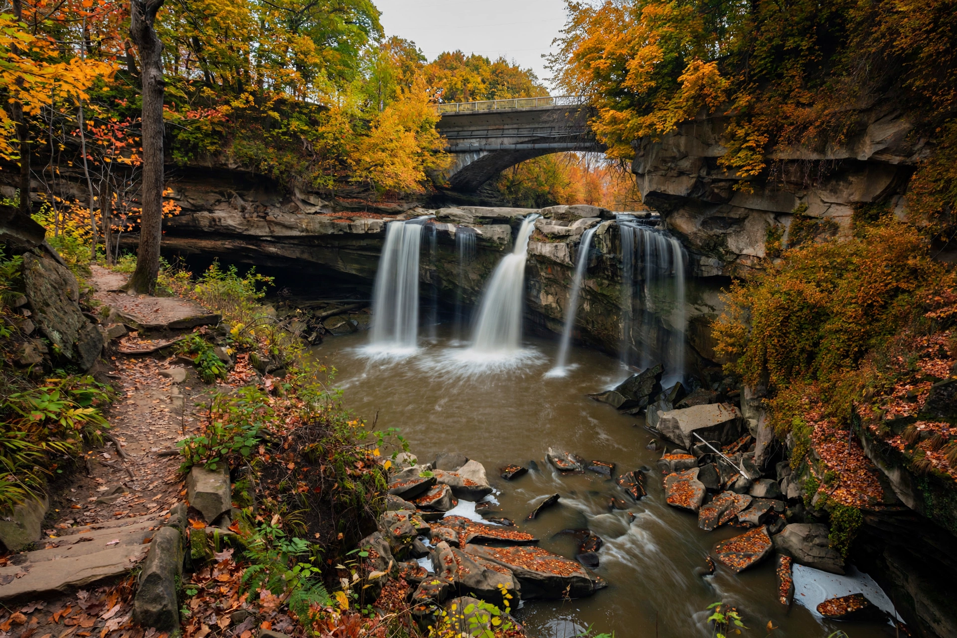 Waterfall cascading over sandstone cliffs into the Black River gorge at Cascade Park in Elyria, Ohio